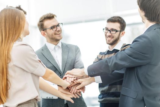 friendly business team standing in a circle and joining his hands together