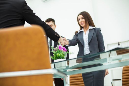 bottom view-handshake of business partners after discussion of the contract in the workplace in a modern office.the photo has a empty space for your text