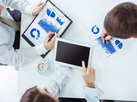 closeup of business team using digital tablet, working with the financial schedule of the company's development