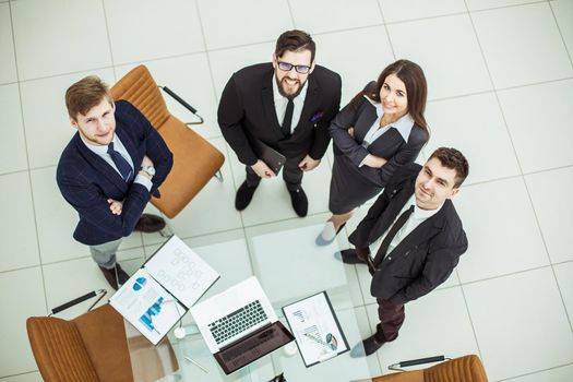 top view: professional business team looking up standing near desktop