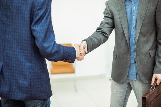 closeup of a handshake between client and Manager on the background of the office