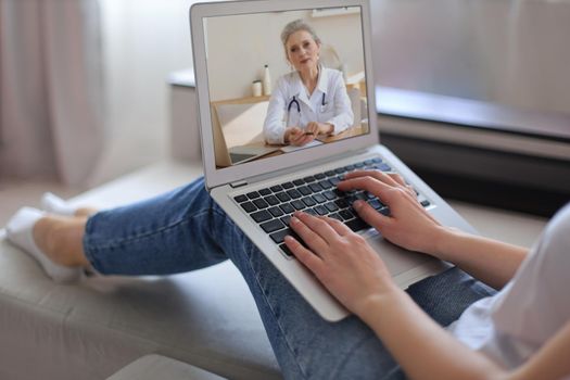 Young woman making video call with her doctor during self isolation and quarantine. Online consultation. Patient in video conferencing with general practitioner on digital tablet. Coronavirus