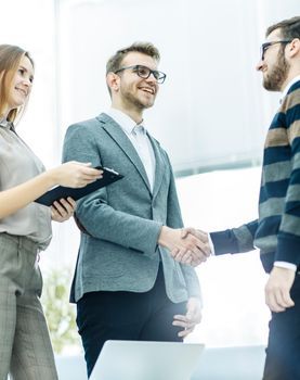 handshake business partners after discussion of the contract in a bright office.the photo has a empty space for your text.