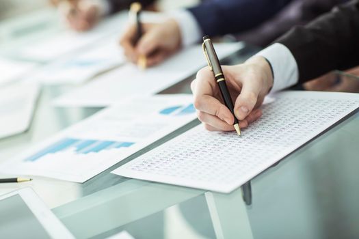 closeup: hands business team that works with financial schemes behind a Desk