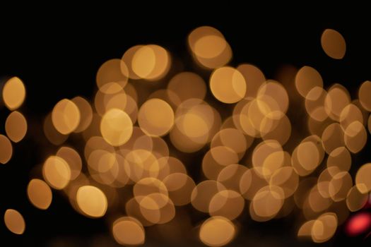 festive golden lights on a black background . photo with a copy-space.