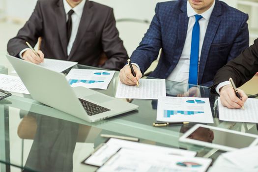 close-up of a business team conducting analysis of marketing reports at the workplace in the office.