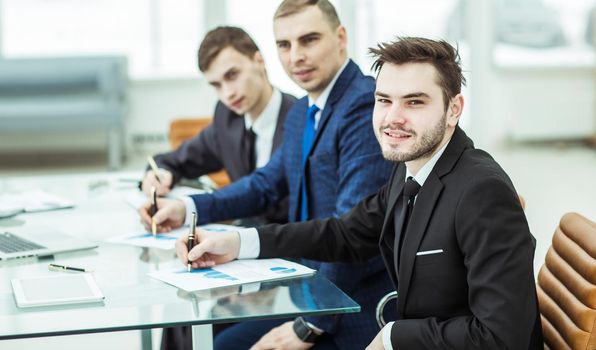 Manager Finance and business team are working with financial charts at his Desk in the office.the photo has a empty space for your text