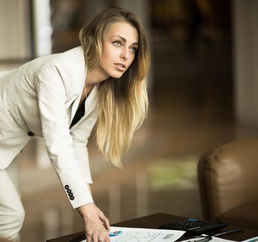 successful business woman is pondering a new financial contract near the workplace in the office
