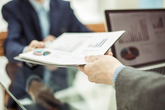closeup of Manager of Finance takes financial statement from the employee on a workplace at office