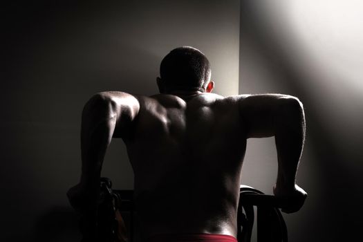 Professional bodybuilder in the gym performs exercises for bodybuilding.