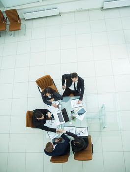 top view - handshake of business partners at a business meeting at the workplace in the spacious office. the photo is a blank space for your text