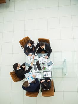 top view of business team and reliable business partners stretch forward hands to each other for a handshake after the debate on the new Finance contract at a Desk in the spacious office.the photo has a empty space for your text