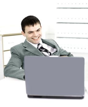 Successful business man in a modern office working behind laptop