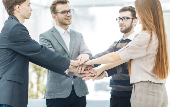 friendly business team standing in a circle and joining his hands together