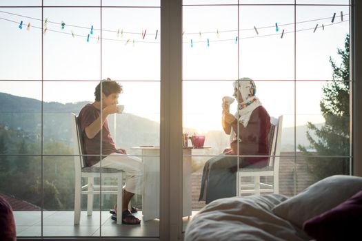 Mother and son enjoying drinking tea on the balcony