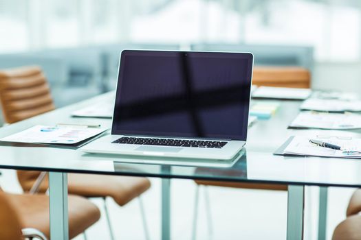 modern workplace with open laptop and financial documents prepared for meeting business partners. the photo is a blank space for your text