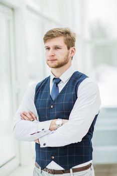 thoughtful beginner businessman standing near window with hands clasped in front of him.the photo has a empty space for your text