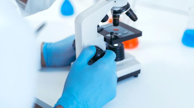 close up. scientist setting up his microscope to work. photo with a copy-space.