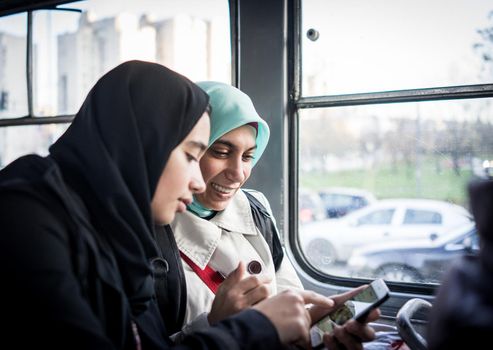 Mother and daughter riding public transport in the city