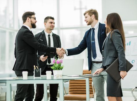 company's lawyers and a handshake of business partners after signing the contract in the workplace in a modern office.the photo has a empty space for your text
