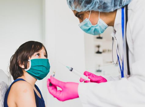 Little cute child with mask getting injection