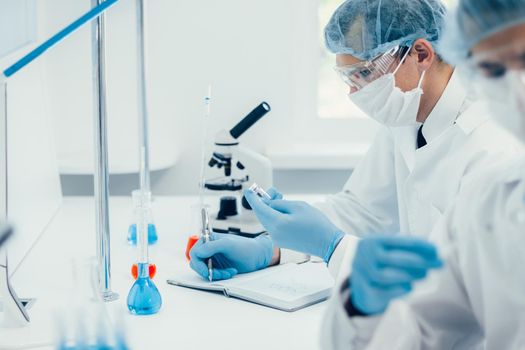 close up. group of scientists testing the results of a new vaccine . photo with a copy-spac