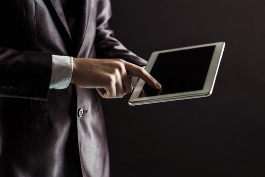 businessman finger presses on screen digital tablet.photo on a black background and has space for your text.