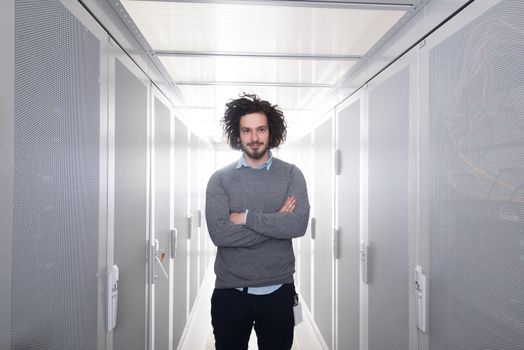 portrait of young handsome IT engeneer in datacenter server room