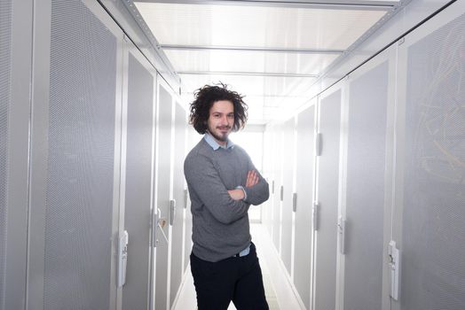 portrait of young handsome IT engeneer in datacenter server room