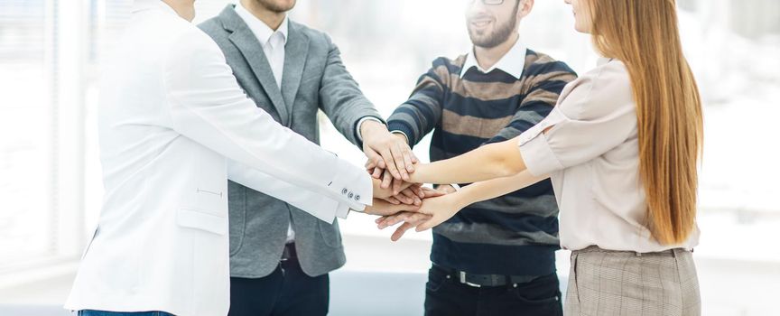 friendly business team standing in a circle and joining his hands together