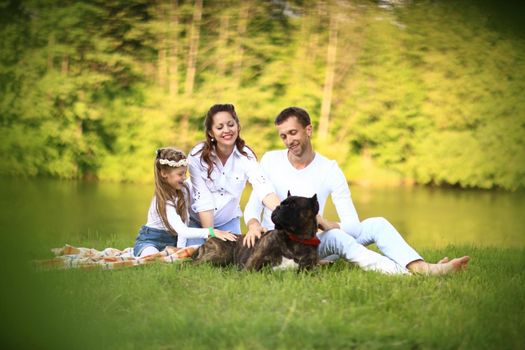 happy father of a daughter and a pregnant mom in the picnic.