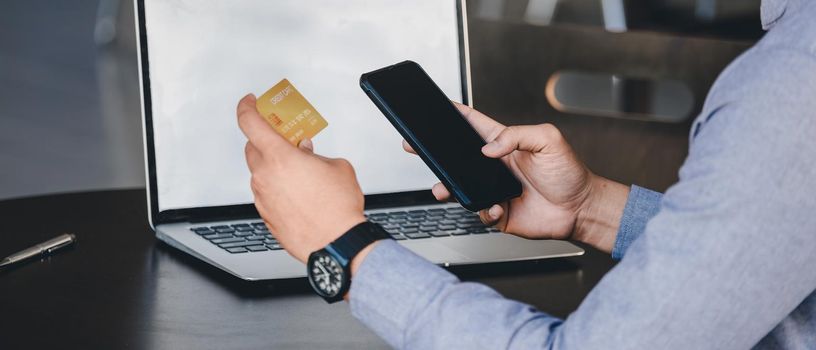 Online payment, Close up man's hands holding smartphone and using credit card for online shopping.