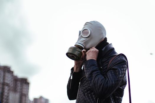 close up. young man wearing a gas mask on a city street