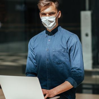 close up. young man in a protective mask sitting on a bench in the city.