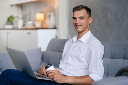 close up. young man with a laptop sitting on the sofa in the living room .