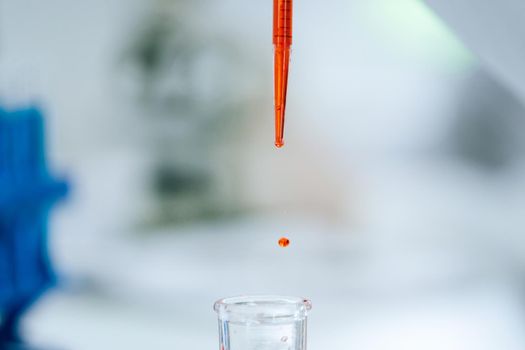 close up. background image of a drop of red liquid in a laboratory pipette. photo with a copy-space.