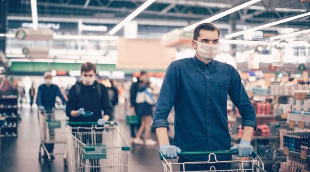 close up. young man in a protective mask with a shopping cart