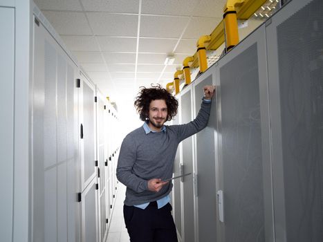 Male IT engineer working on a tablet computer in server room at modern data center