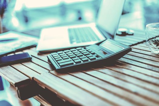 close up. calculator and laptop on a wooden table . photo with a copy-space.