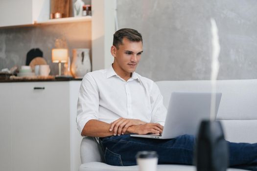 close up. young man with a laptop is resting on the sofa . photo