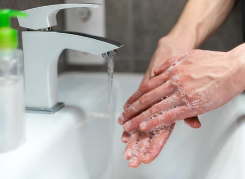 close up. modern guy carefully lathering his hands . concept of prevention of infectious diseases.