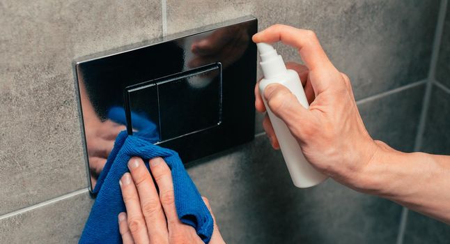 close up. male treating the wall switch with antiseptic. photo with a copy-space.