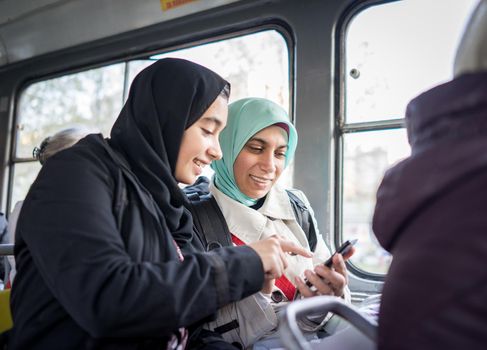 Mother and daughter riding public transport in the city