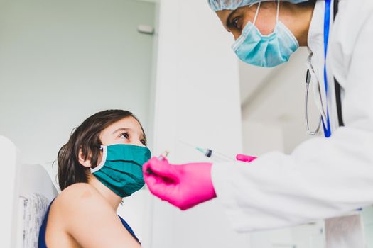 Little cute child with mask getting injection