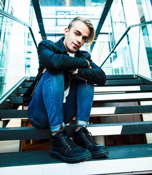 young modern hipster guy at new building university blond fashion handsome boy, lifestyle people concept closeup