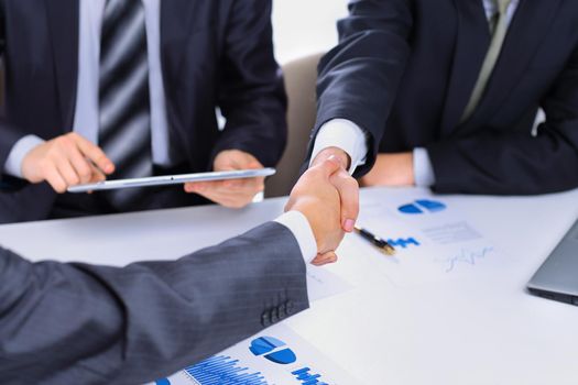 Photo of handshake of business partners after signing promising contract