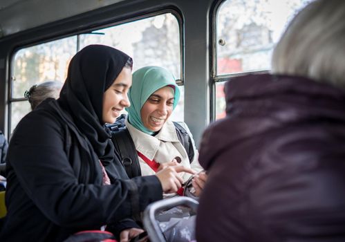 Mother and daughter riding public transport in the city