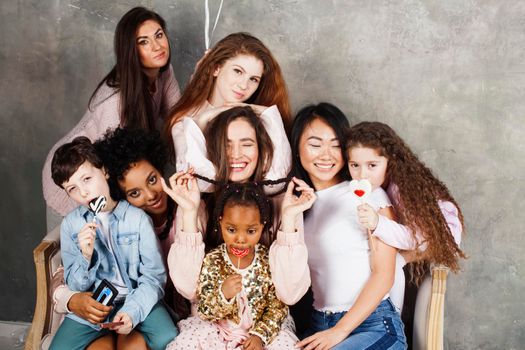 Lifestyle and people concept: young pretty diversity nations woman with different age children celebrating on birth day party together happy smiling, making selfie. African-american, asian and caucasian close up