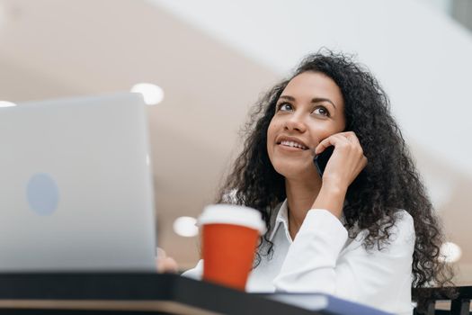 close-up. young woman talking on a smartphone sitting at a table in the cafeteria.