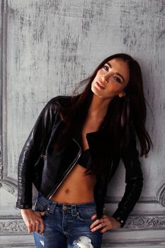 young brunette woman in leather jacket at vintage wall, lifestyle people concept close up